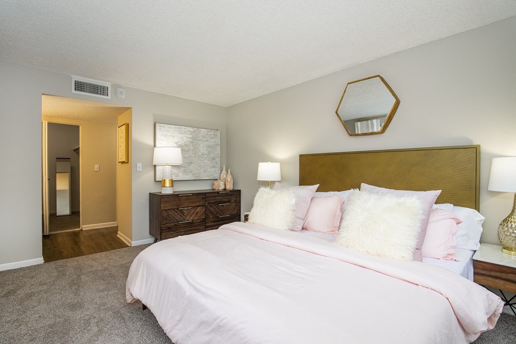 A bedroom with a bed, nightstand, and lamp.