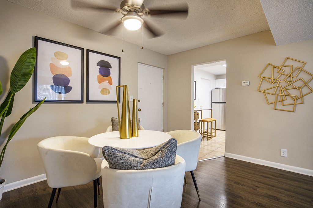 A living room with a white couch, a plant, and a ceiling fan.