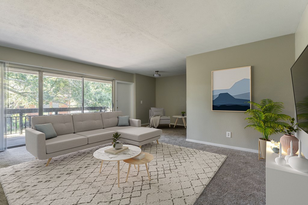 A living room with a grey sofa, a white coffee table, and a painting on the wall.