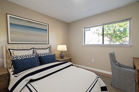 A bedroom with a large bed and a painting on the wall.