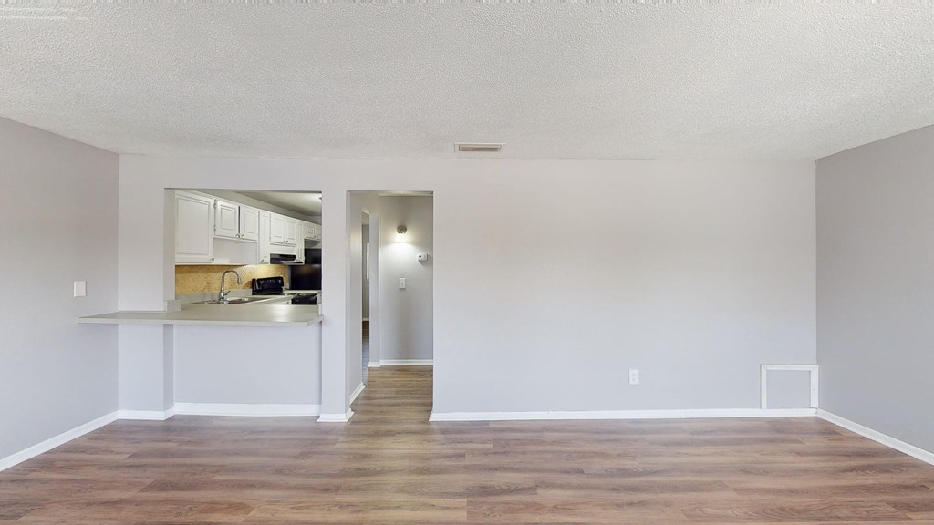 a living room with a kitchen in the background