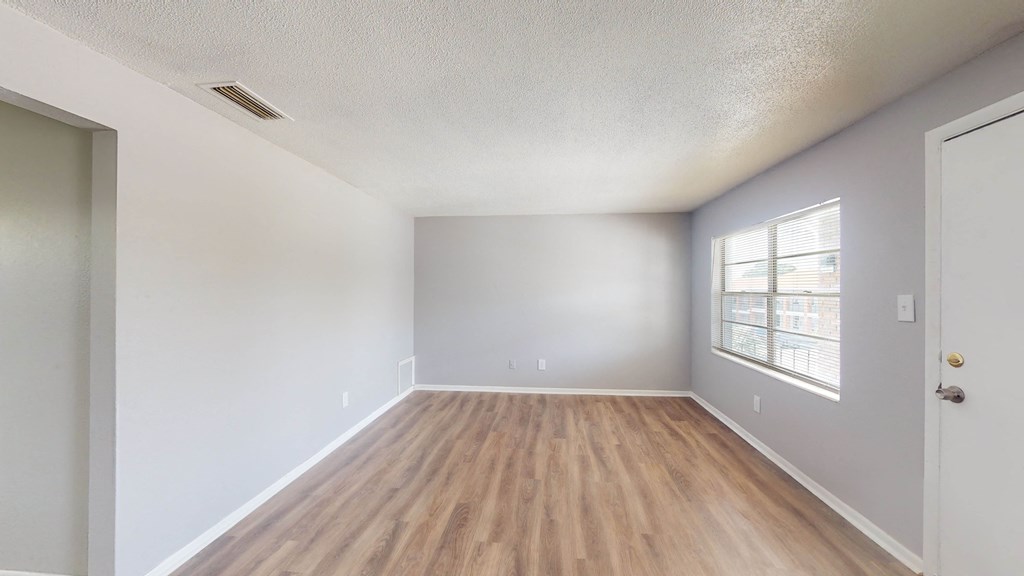 a bedroom with hardwood floors and grey walls