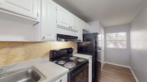 A kitchen with a black stove top oven and a black refrigerator.