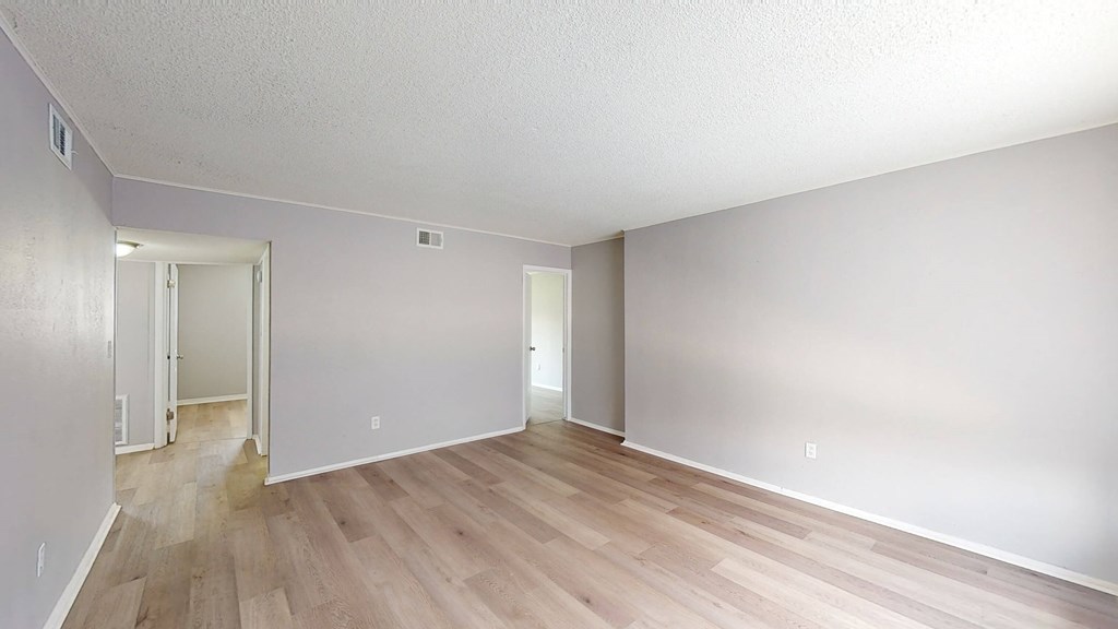 a bedroom with hardwood floors and grey walls