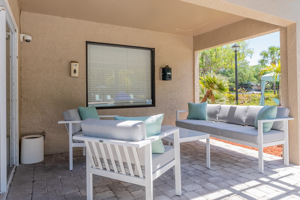 a covered patio with two chairs and a table  at Fisherman's Landing Apartment Homes, Florida