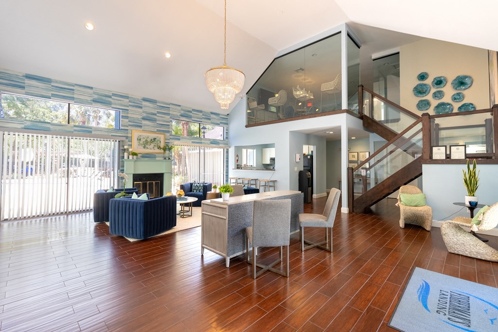a living room with a staircase and a dining room with chairs and a couch  at Fisherman's Landing Apartment Homes, Tampa, Florida