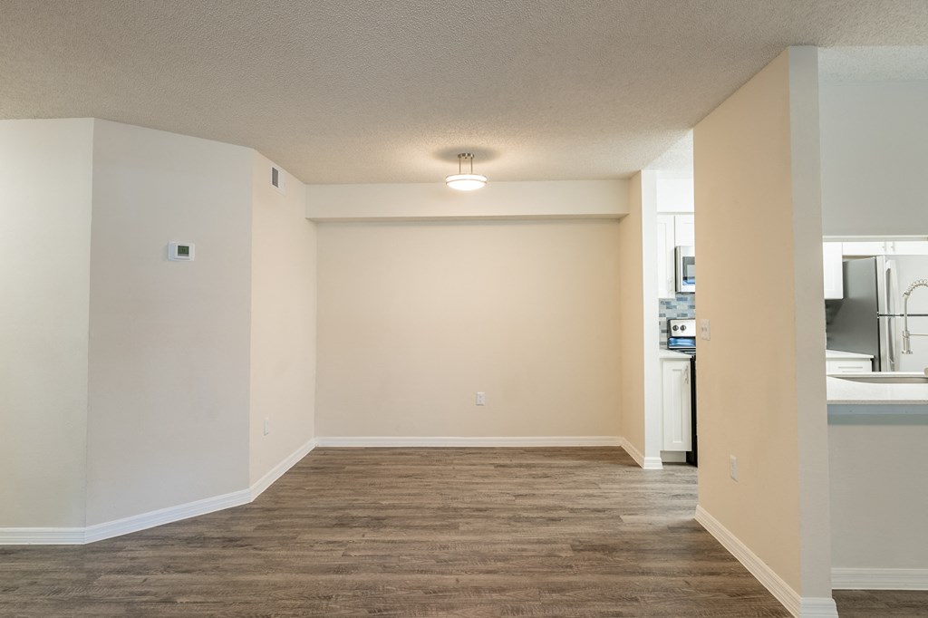 an empty living room and kitchen with a wood floor and white walls  at Fisherman's Landing Apartment Homes, Florida