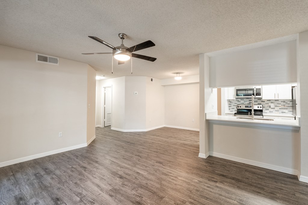 an empty living room with a ceiling fan and a kitchen  at Fisherman's Landing Apartment Homes, Tampa, FL, 33637