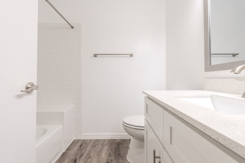 a bathroom with a toilet sink and shower and a mirror  at Fisherman's Landing Apartment Homes, Tampa, Florida