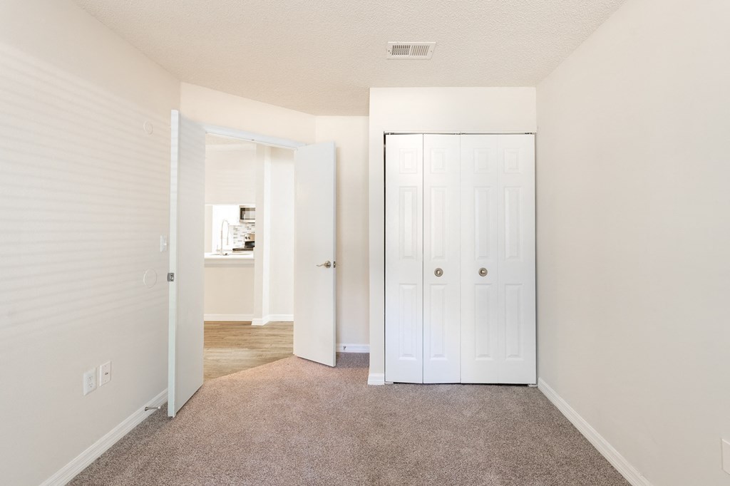 a bedroom with a closet and a door to a bathroom a bedroom with a closet and a door to a bathroom at Fisherman's Landing Apartment Homes, Florida
