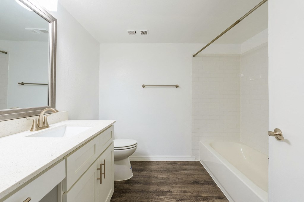 a bathroom with a toilet and a tub and a sink  at Fisherman's Landing Apartment Homes, Tampa, Florida
