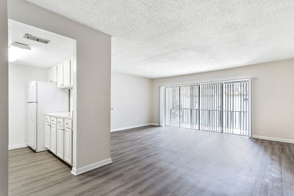 an empty living room and kitchen with a large window at Greenwich Commons Apartment Homes, Tampa, 33613