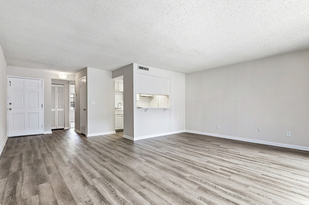 an empty living room with white walls and wood flooring at Greenwich Commons Apartment Homes, Florida