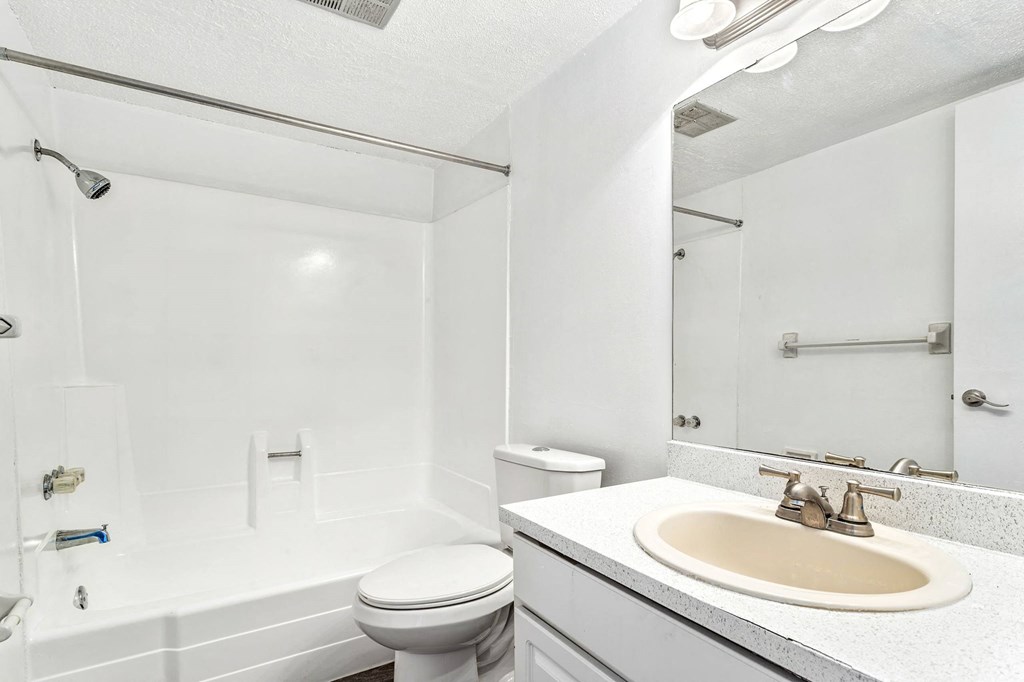 a white bathroom with a sink and a toilet at Greenwich Commons Apartment Homes, Florida