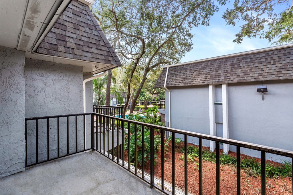 a balcony with a white house and a tree at Greenwich Commons Apartment Homes, Florida, 33613