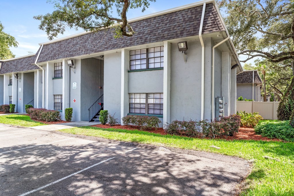 a white house with a sidewalk in front of it at Greenwich Commons Apartment Homes, Florida, 33613