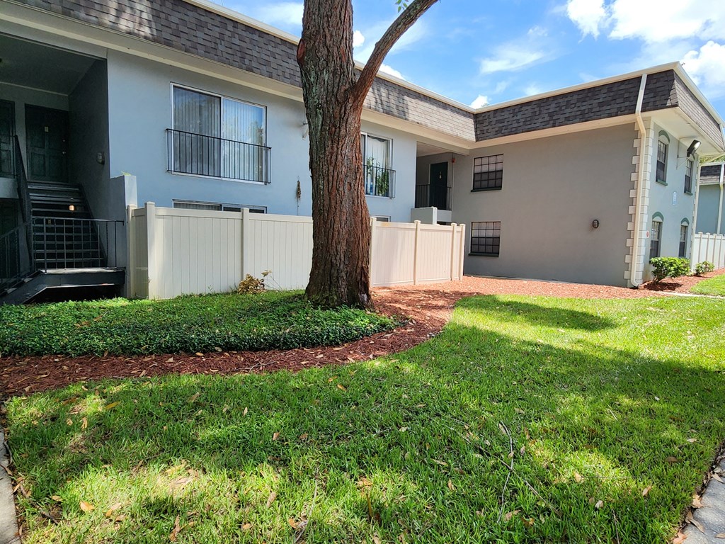 a view of the exterior of a house with a yard and a tree at Greenwich Commons Apartment Homes, Tampa, 33613