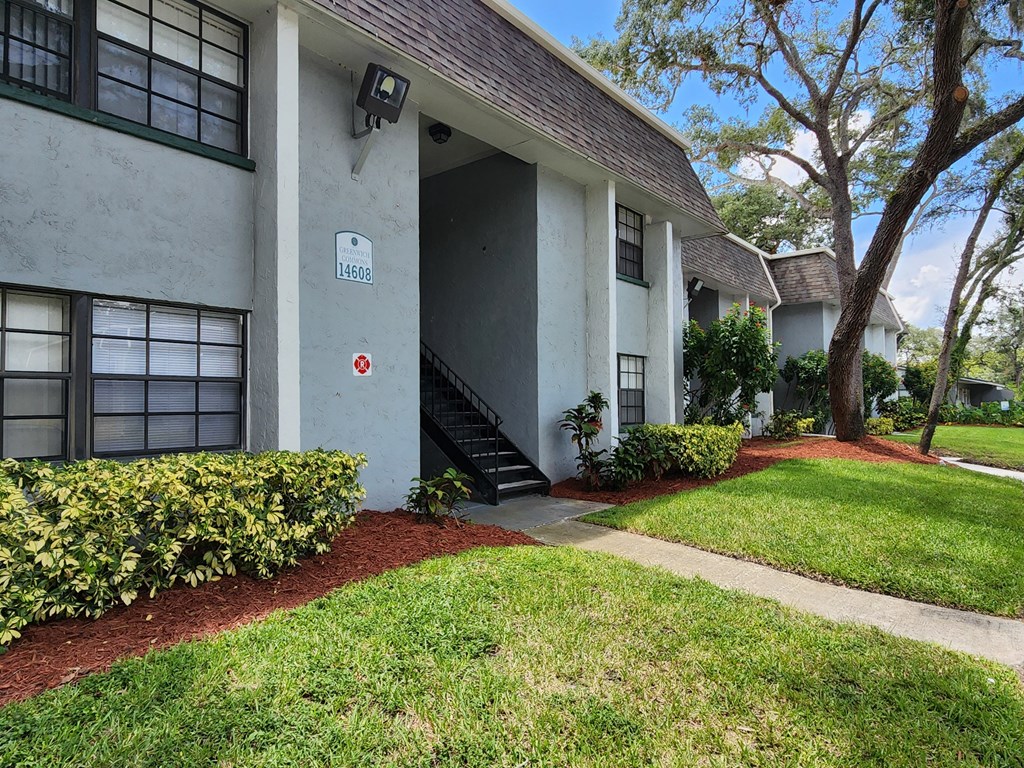 the front of a house with a walkway and grass at Greenwich Commons Apartment Homes, Tampa