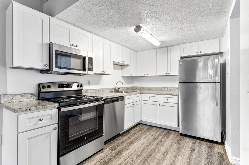 a kitchen with stainless steel appliances and white cabinets at Greenwich Commons Apartment Homes, Tampa
