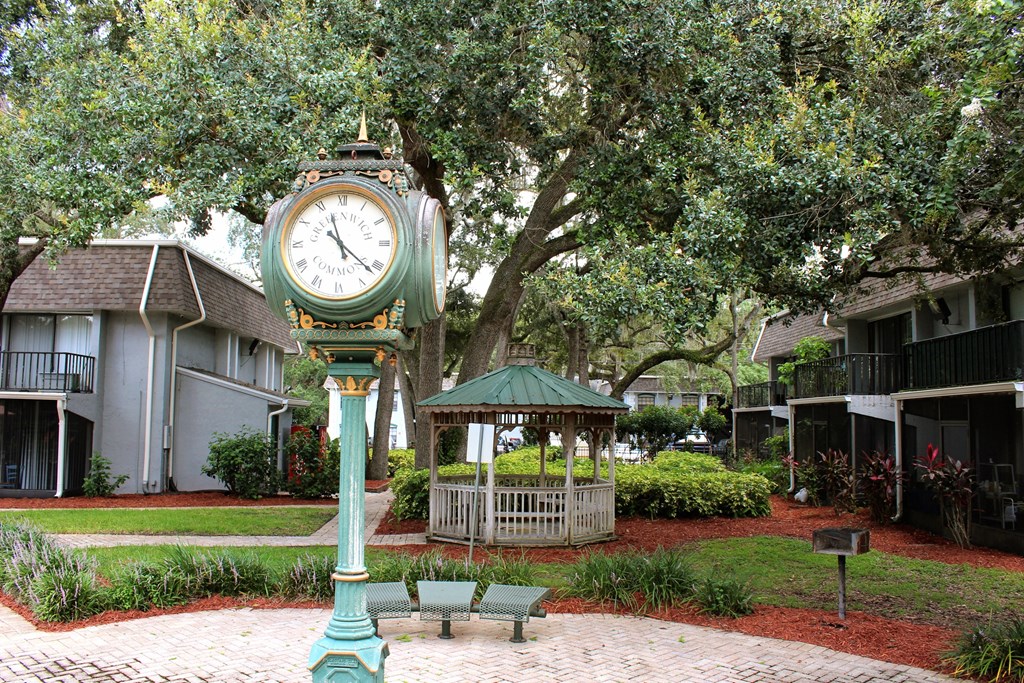 a clock in the middle of a park with a gazebo at Greenwich Commons Apartment Homes, Tampa, FL, 33613