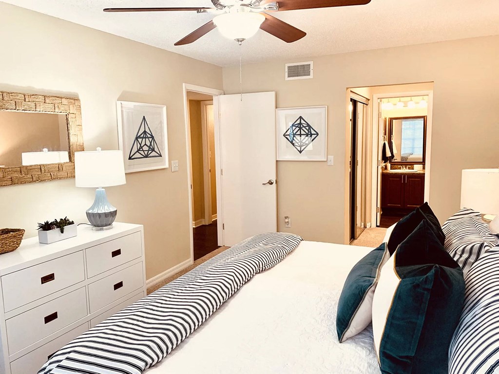 a bedroom with a large bed and a ceiling fan at Madison Oaks Apartment Homes, LLC, Palm Harbor, FL 34684