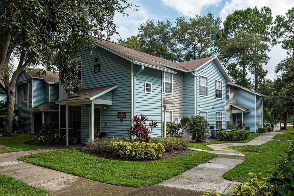 a blue house with a sidewalk in front of it at Madison Oaks Apartment Homes, LLC, Palm Harbor, 34684