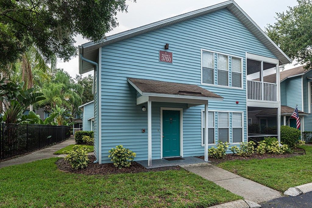 the front of a blue house with a green door at Madison Oaks Apartment Homes, LLC, Palm Harbor Florida