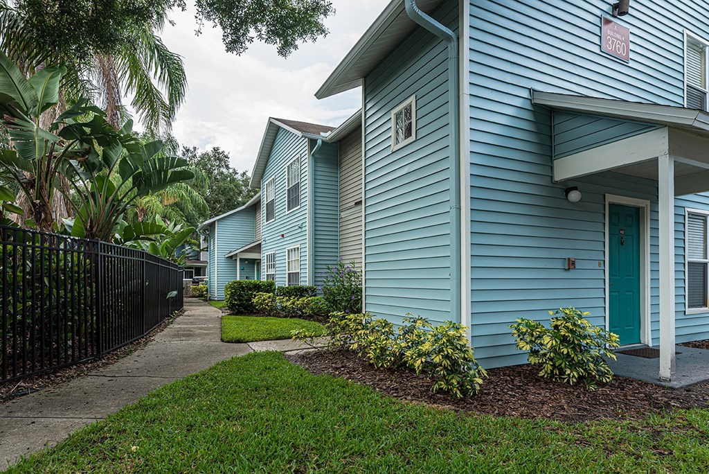 a blue house with a sidewalk in front of it at Madison Oaks Apartment Homes, LLC, Florida
