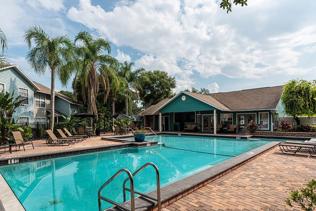 a swimming pool with a house in the background at Madison Oaks Apartment Homes, LLC, Palm Harbor
