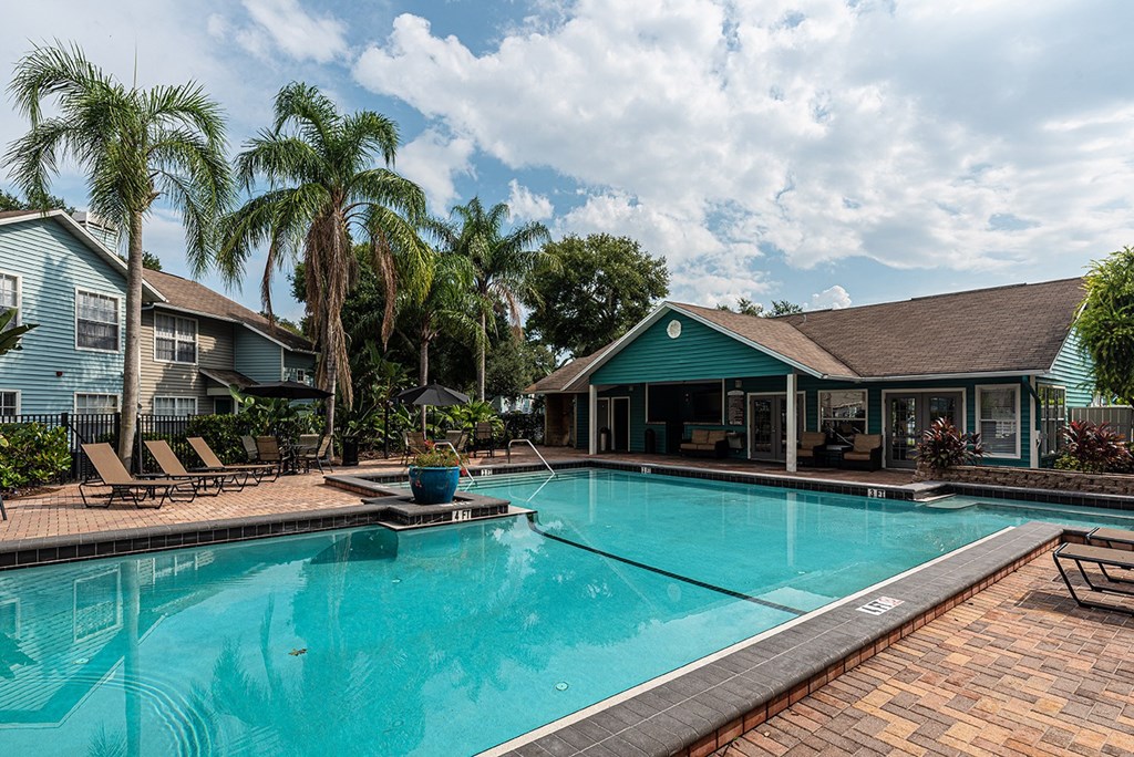 a large swimming pool with a house in the background at Madison Oaks Apartment Homes, LLC, Palm Harbor