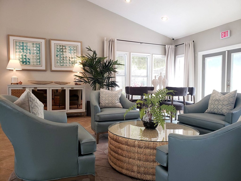 a living room with blue chairs and a table at Madison Oaks Apartment Homes, LLC, Palm Harbor, FL