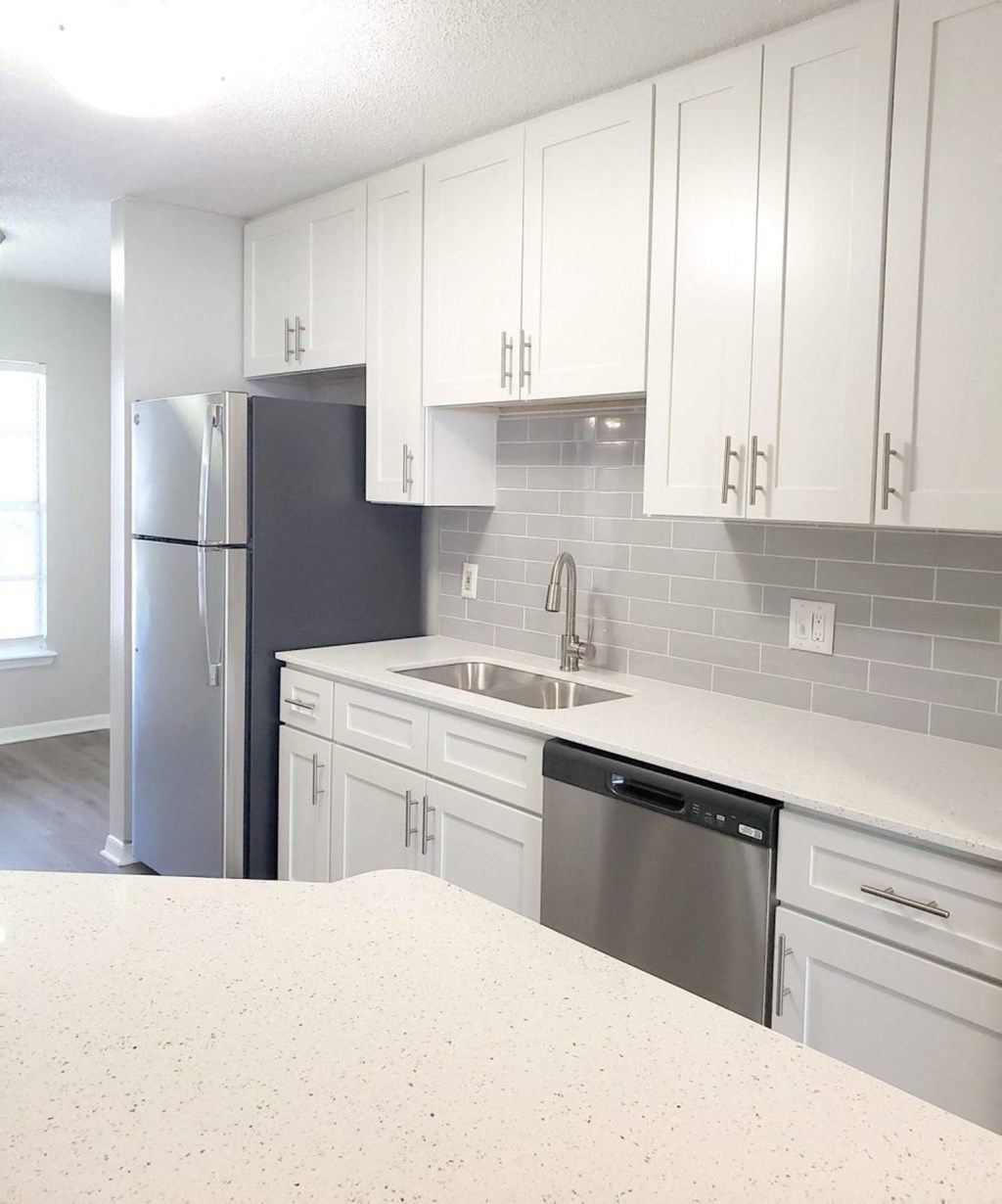 a kitchen with white cabinets and a stainless steel refrigerator at Madison Oaks Apartment Homes, LLC, Palm Harbor, FL