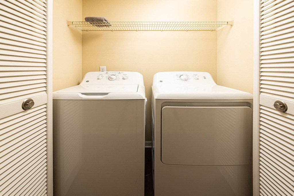 a small laundry room with two washes and a dryer at Madison Oaks Apartment Homes, LLC, Florida