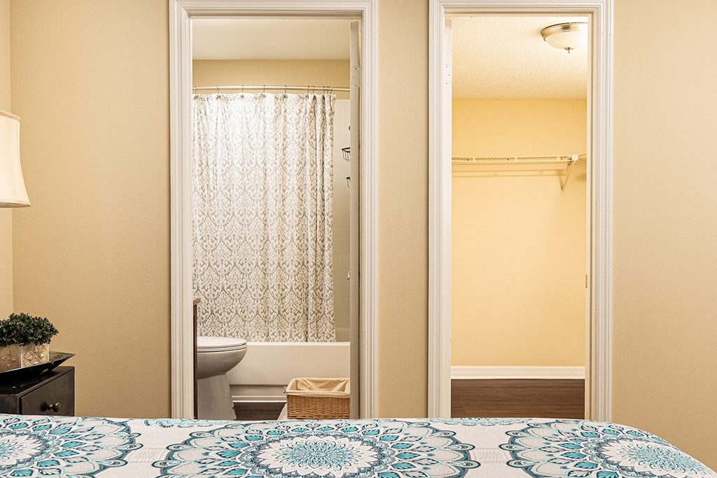 a bedroom door open to a bathroom with a toilet and a shower at Madison Oaks Apartment Homes, LLC, Palm Harbor, 34684