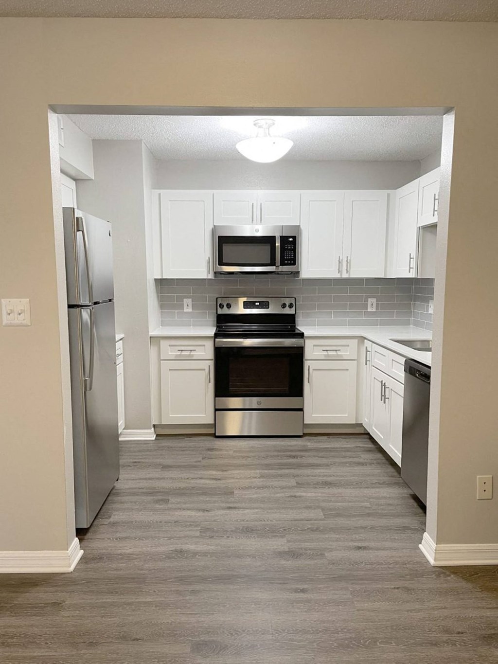 a kitchen with stainless steel appliances and white cabinets at Madison Oaks Apartment Homes, LLC, Palm Harbor, FL