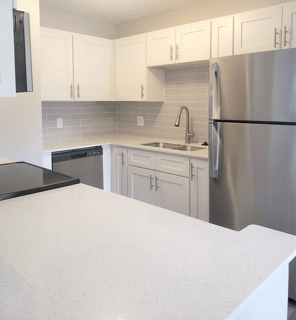 a kitchen with a white counter top and a stainless steel refrigerator at Madison Oaks Apartment Homes, LLC, Palm Harbor Florida