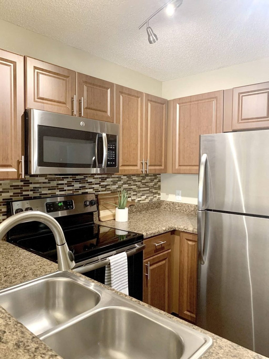a kitchen with stainless steel appliances and granite counter tops at Madison Oaks Apartment Homes, LLC, Florida, 34684