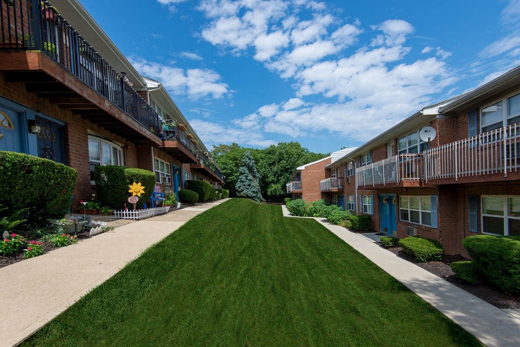a green lawn in front of some apartments at Raritan Crossing Apartment Homes, New Brunswick, NJ 08901