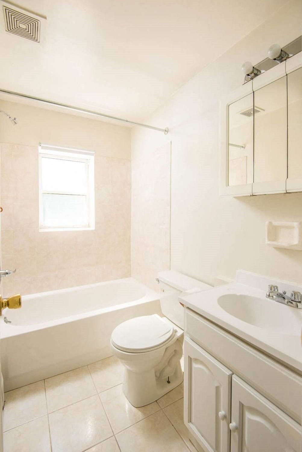 a bathroom with a toilet and a sink and a bath tub at Raritan Crossing Apartment Homes, New Brunswick, 08901