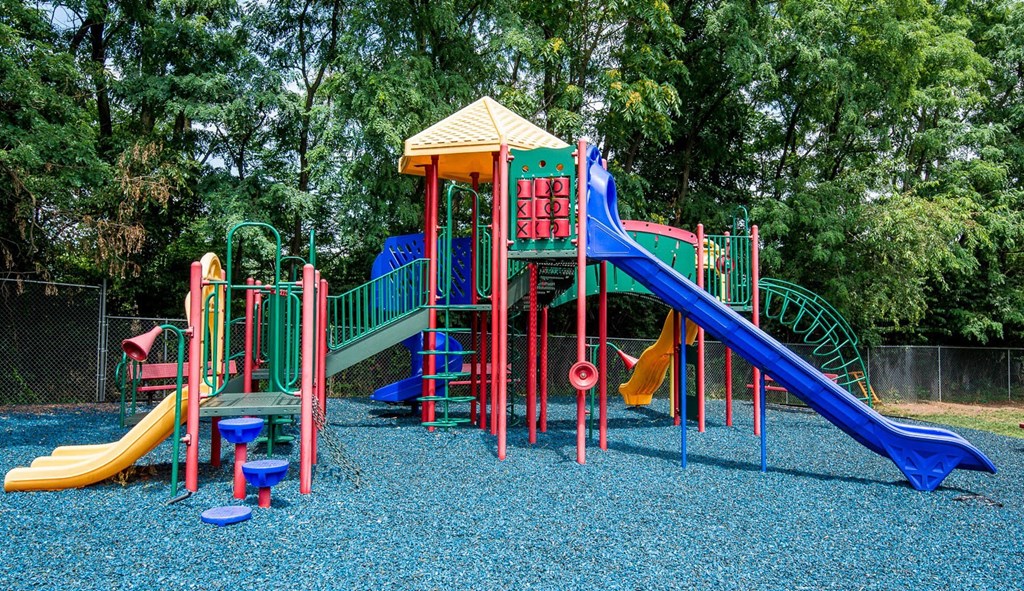 a colorful playground with slides and other toys at Raritan Crossing Apartment Homes, New Brunswick, NJ 08901
