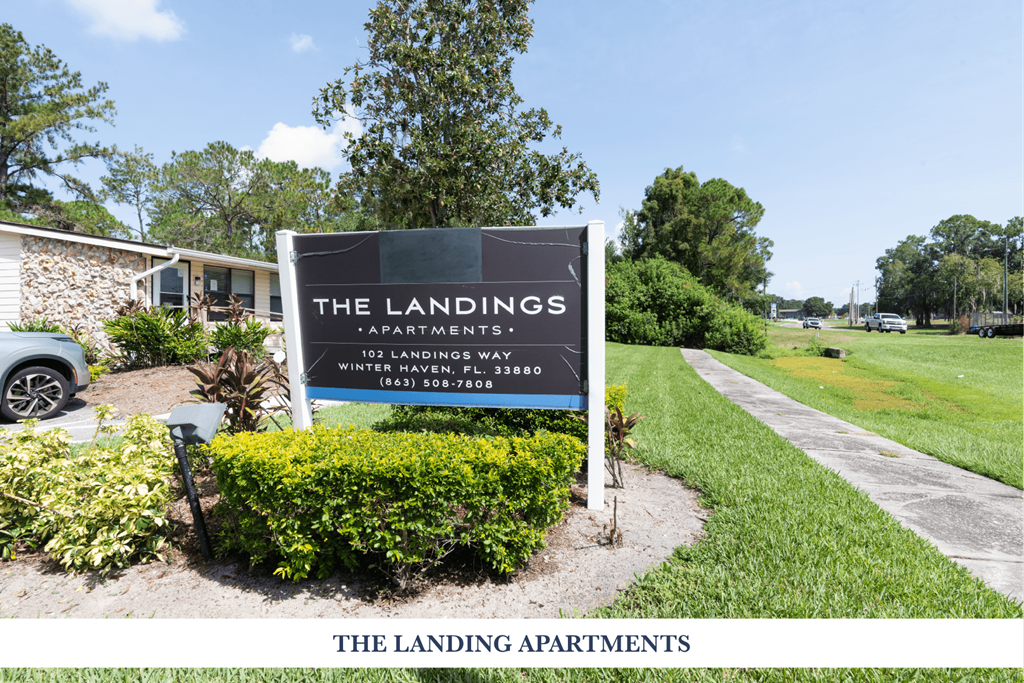 A sign for The Landings Apartments is in front of a building.