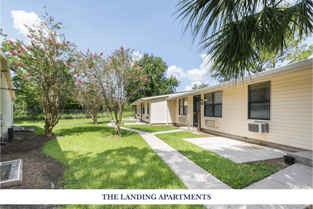 A row of small houses with a green lawn in between.