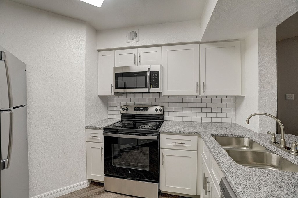 A kitchen with white cabinets and a black stove top oven.