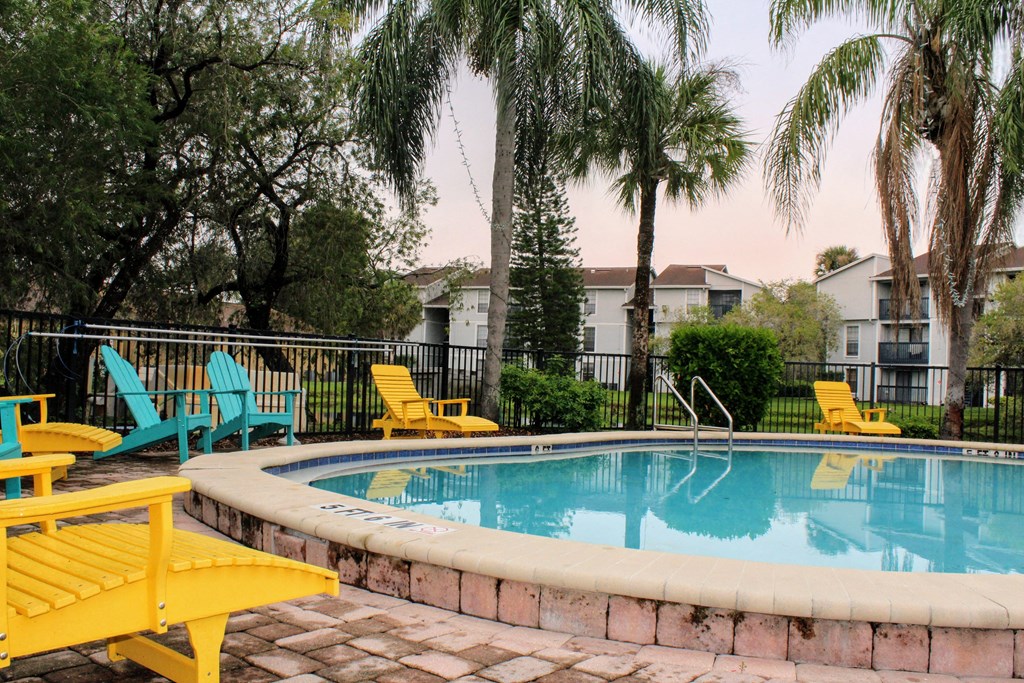 our apartments have a large swimming pool with yellow and blue chairs at Sunscape Apartment Homes, Tampa, Florida