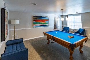 a living room with a blue pool table  at The Park at Chesterfield Apartment Homes, Tampa, FL, 33617