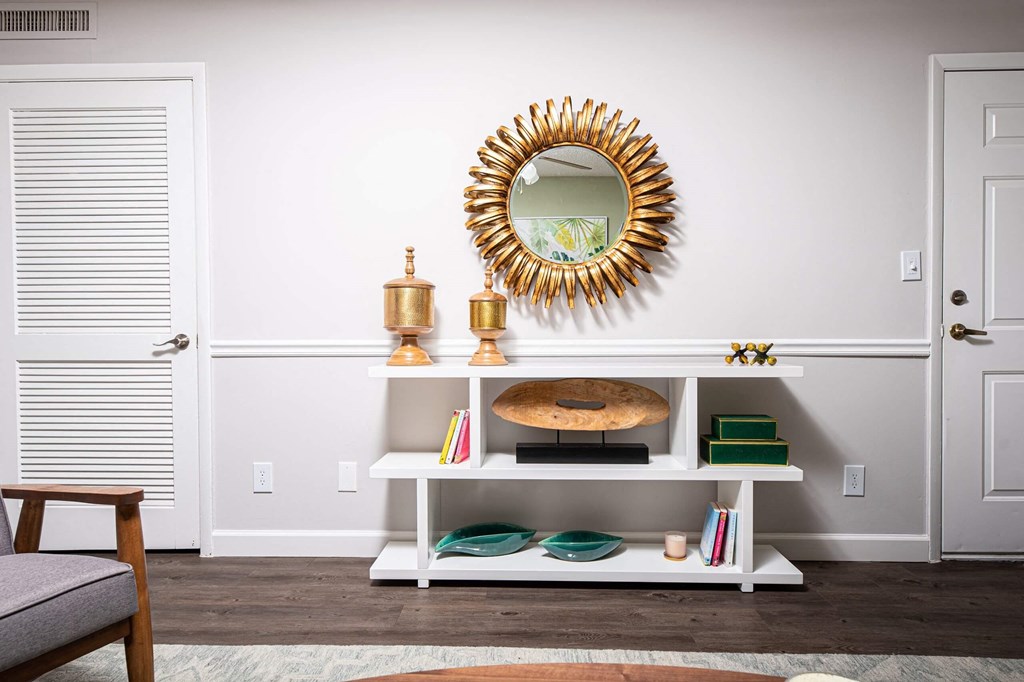 a living room with a mirror and a white shelf  at The Park at Chesterfield Apartment Homes, Tampa, FL, 33617