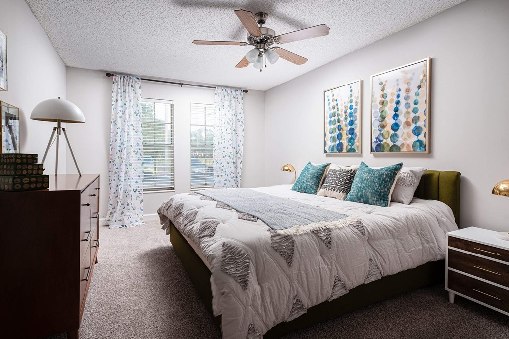 a bedroom with a bed and a ceiling fan  at The Park at Chesterfield Apartment Homes, Florida