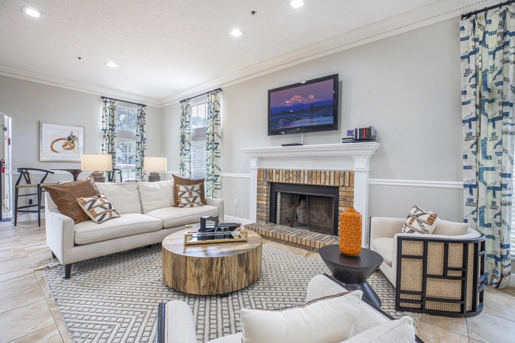A living room with a fireplace and a television on the wall.