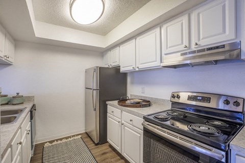 A kitchen with a stove and refrigerator.