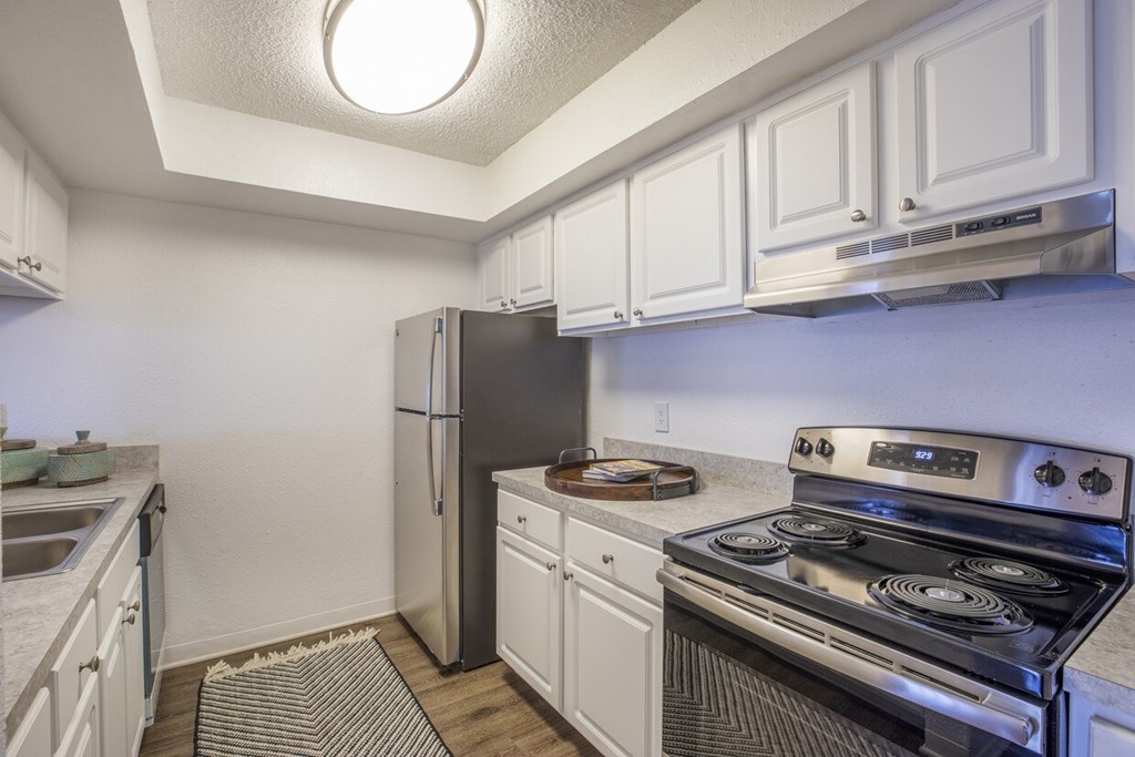 A kitchen with a stove and refrigerator.